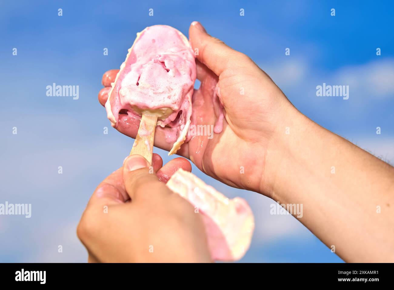 Nago-Torbole, Lac de Garde, Italie - 21 juillet 2024 : image symbolique d'une canicule estivale. Un popsicle fond dans une main à partir de températures élevées *** Symbolbild Hitzewelle im Sommer. Ein Eis am Stiel schmilzt vor hohen Temperaturen in einer hand Banque D'Images