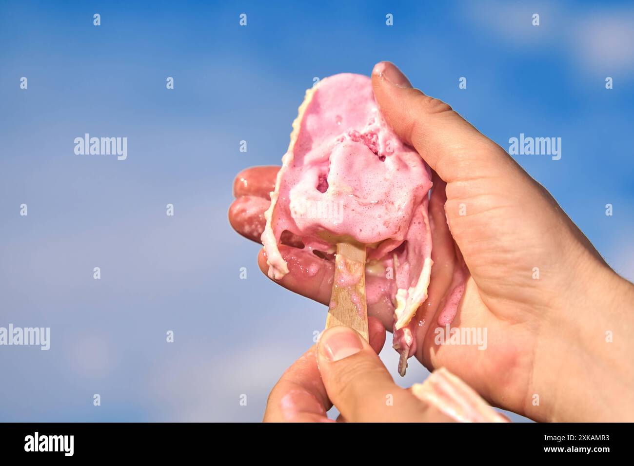 Nago-Torbole, Lac de Garde, Italie - 21 juillet 2024 : image symbolique d'une canicule estivale. Un popsicle fond dans une main à partir de températures élevées *** Symbolbild Hitzewelle im Sommer. Ein Eis am Stiel schmilzt vor hohen Temperaturen in einer hand Banque D'Images