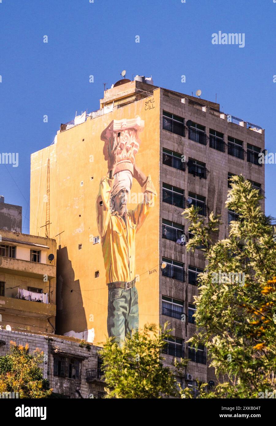 Murale à grande échelle sur un bloc d'appartements d'un homme portant une capitale pilier de style composite comme coiffe, Amman, Jordanie Banque D'Images