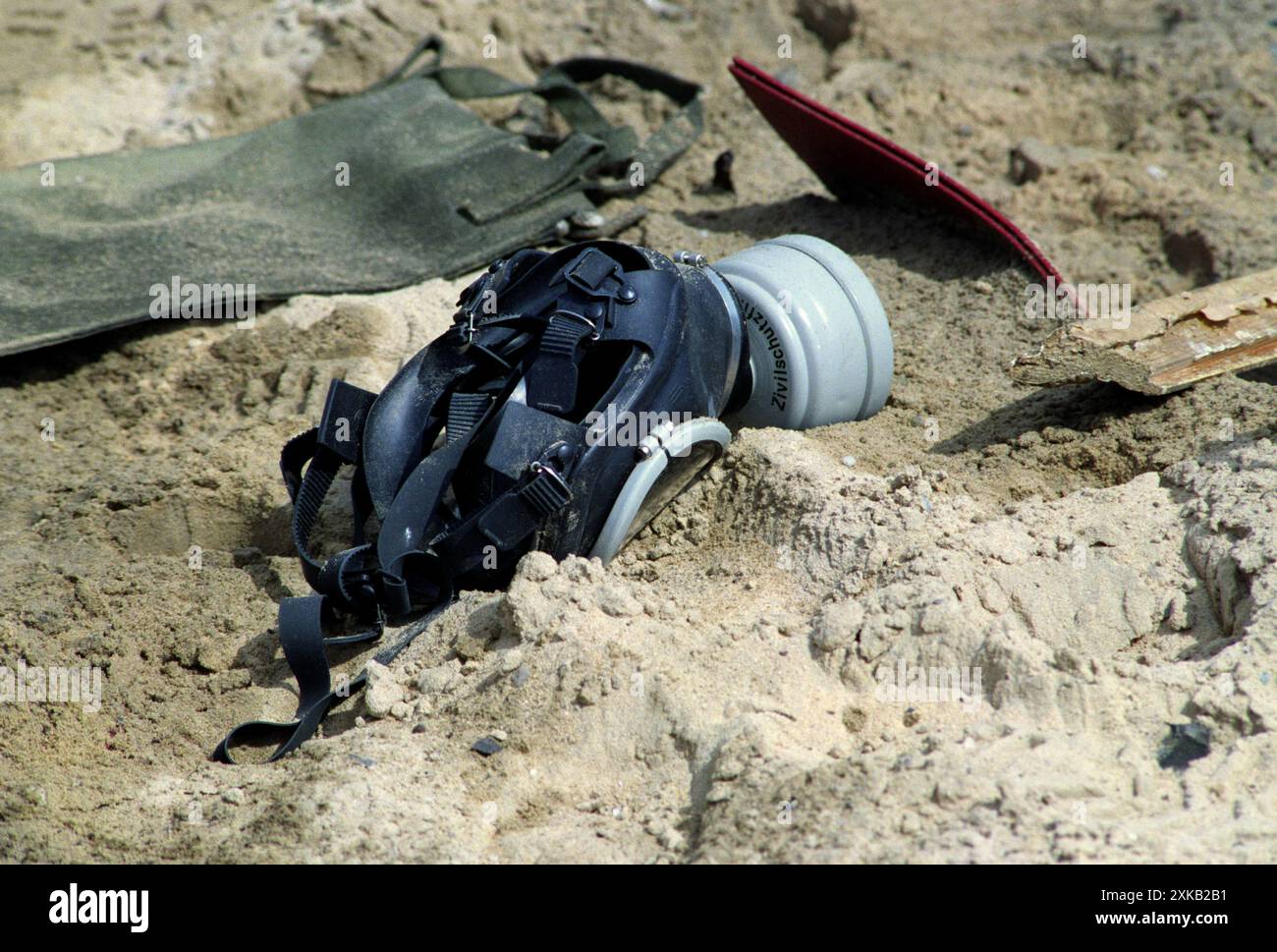 Première Guerre du Golfe : 4 mars 1991 Un masque à gaz Panorama Nova RA Ouest allemand se trouve dans le désert, juste à côté de la route 801, la route d'Um Qasr, au nord de Koweït City. Il faisait partie de l'équipement d'un soldat irakien, un membre d'un convoi d'environ deux douzaines de véhicules militaires qui ont été détruits avec des bombes à sous-munitions par l'armée de l'air américaine environ une semaine auparavant. Banque D'Images