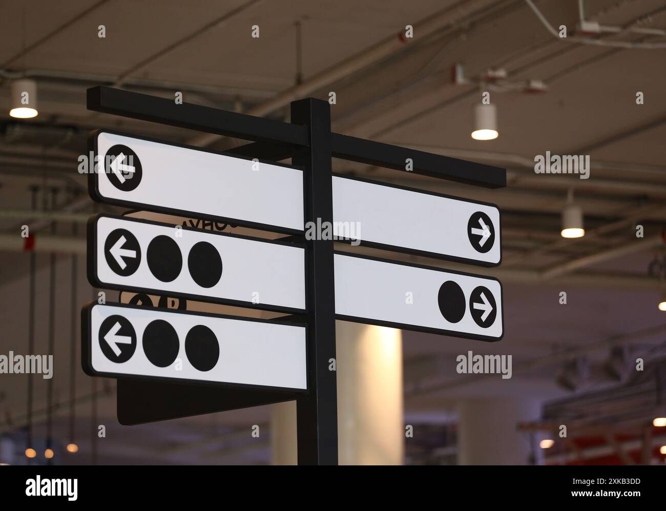 Panneau blanc accroché sur le poteau sur le fond du centre commercial Banque D'Images