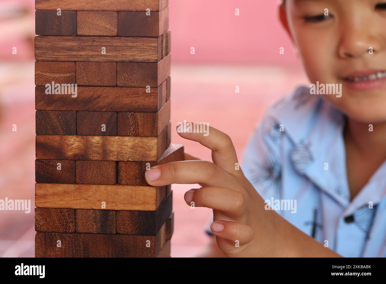 Jeu de puzzle en bois aligner verticalement et doigt de l'enfant dans le concept de jouet ou le concept d'affaires connexes. Banque D'Images