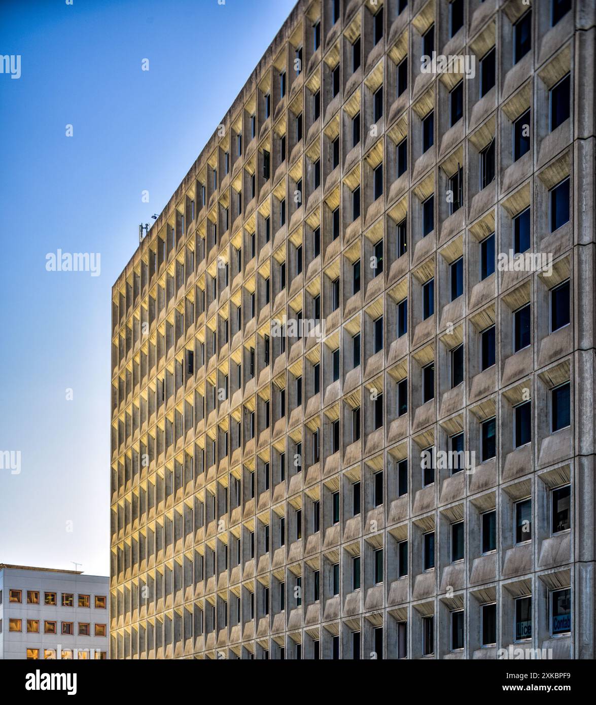 Vue rapprochée du style rationaliste Edificio Sevilla 1, construit en 1972, à Séville, Andalousie, Espagne. La façade montre des motifs de fenêtres répétitifs. Banque D'Images