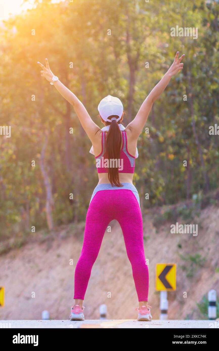 Image floue,Une jeune femme en vêtements de sport, debout, se réchauffe le matin pour détendre ses muscles des jambes et des pieds afin qu'elle puisse courir. Le concept de course Banque D'Images