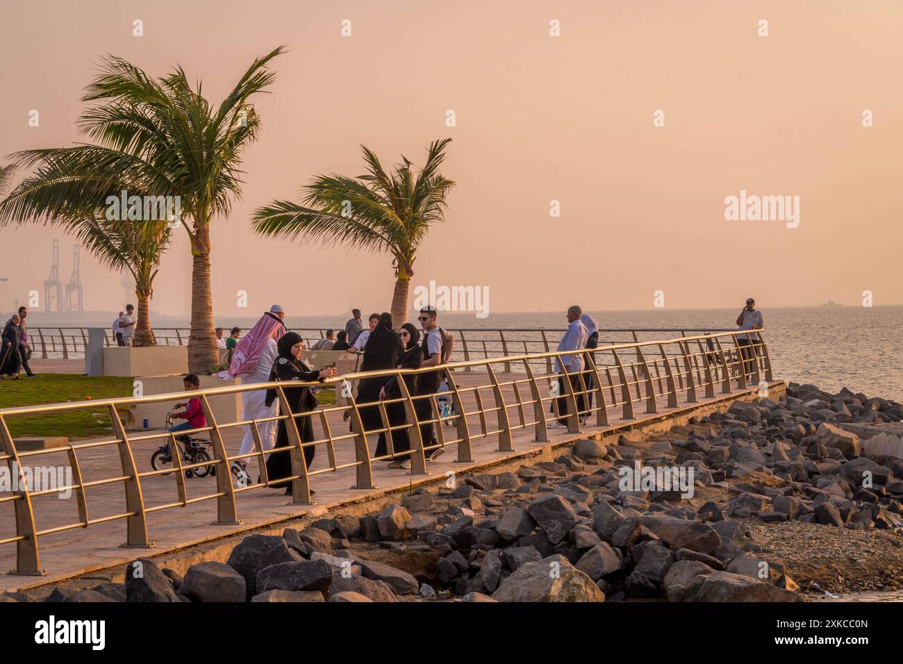 Le peuple saoudien regardant le coucher du soleil sur la corniche Al Hamra dans le front de mer de Djeddah, en Arabie saoudite, pendant le magnifique coucher de soleil coloré du moyen-Orient. Banque D'Images