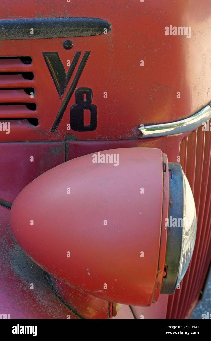 Gros plan d'un phare et d'une grille d'une vieille camionnette rouge Ford des années 1940 Banque D'Images