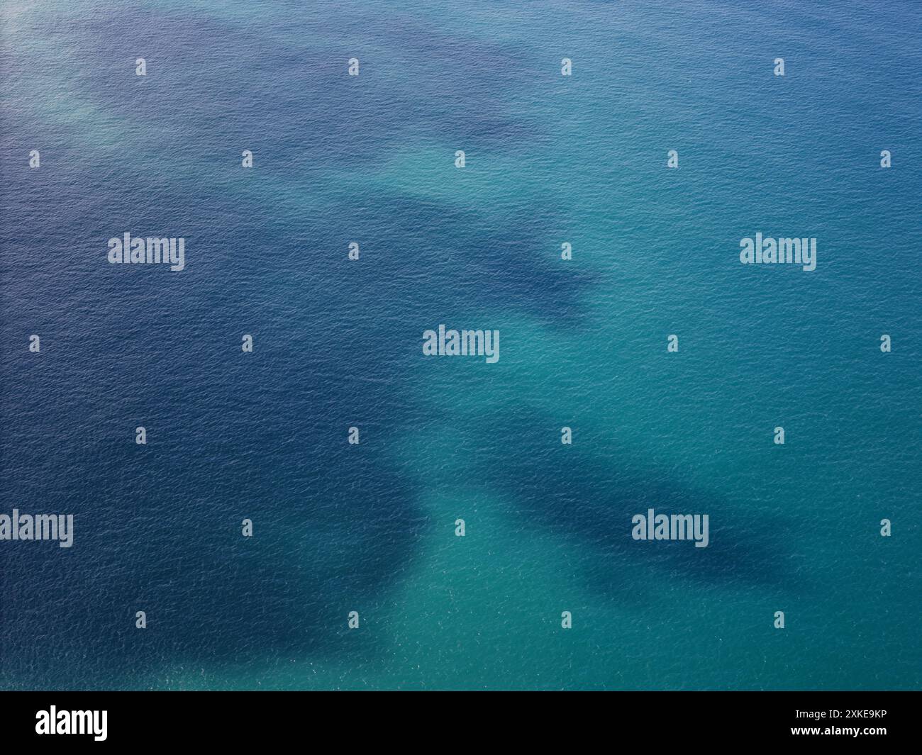 Vue aérienne sur l'eau bleue de l'océan avec drone à tache sombre Banque D'Images