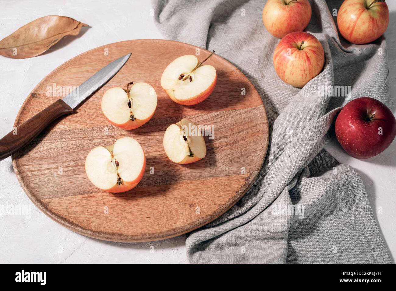 Pommes mûres fraîches sur plateau en bois avec serviette grise sur table blanche. Récolte d'automne, concept de Thanksgiving. Vue de dessus. Banque D'Images