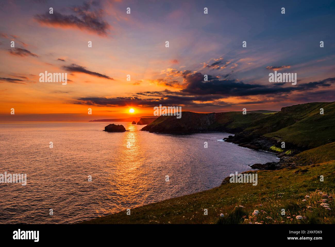 Lever de soleil près du solstice d'été se levant au-dessus de la baie de Gullastem, pris de Barras Nose, Tintagel, Cornwall, Royaume-Uni Banque D'Images