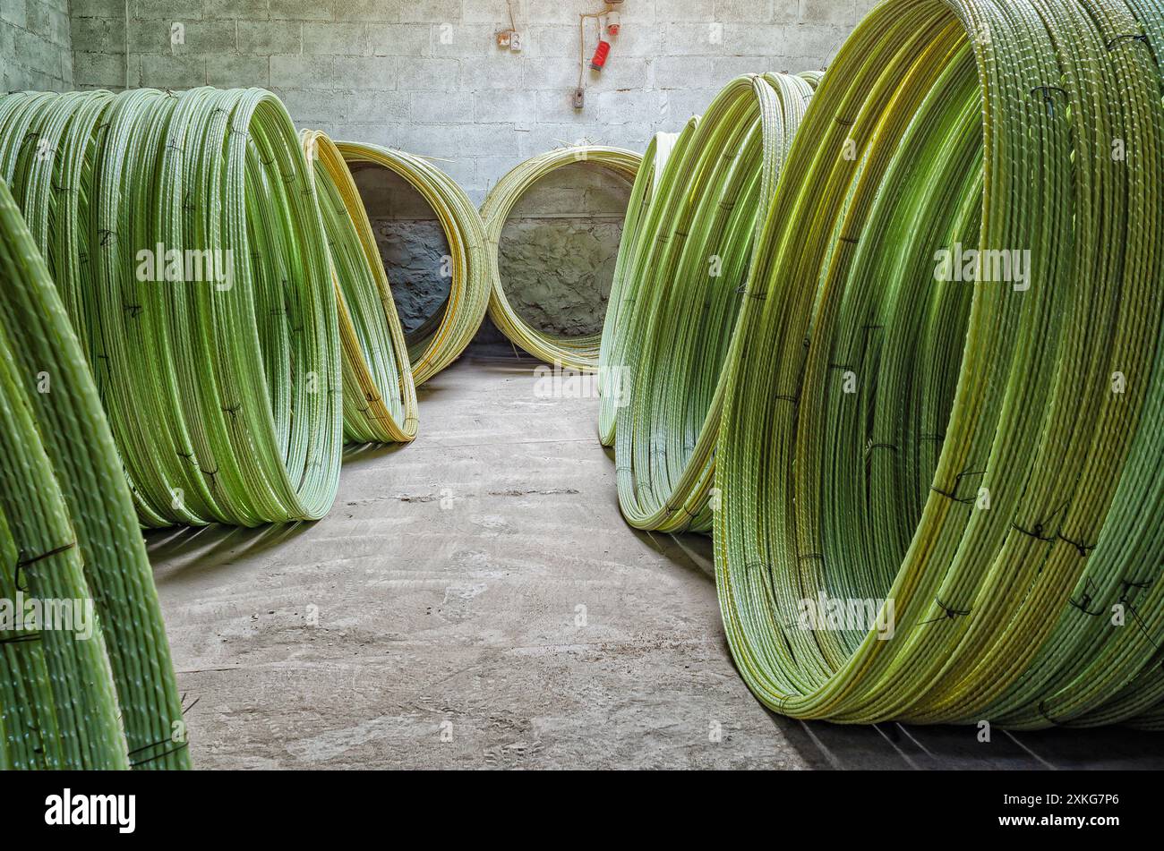 Fils jaunes en plastique torsadés en rouleaux dans l'atelier. Fabrication de fil pour garnitures. Construction Banque D'Images