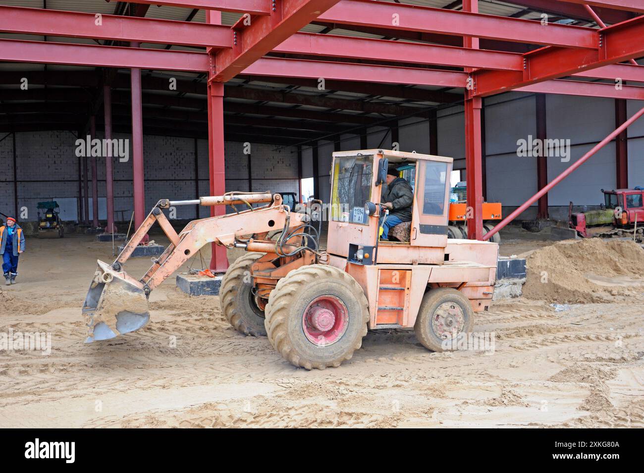 Construction du hangar. Bulldozer travaillant, homme ouvrier creusant avec une pelle. 20 mars 2019. Berezovka, Ukraine Banque D'Images