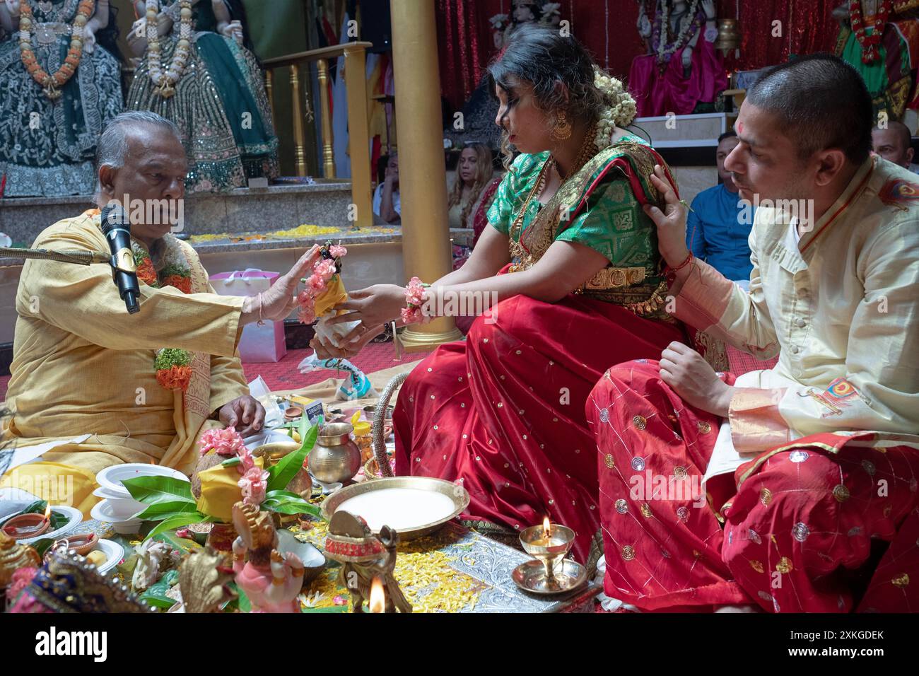 Une pandita hindoue enceinte et son mari et leur pandit à un service Valaikappu dans le Queens, NY, en 2024. C'est l'équivalent d'une baby shower. Banque D'Images