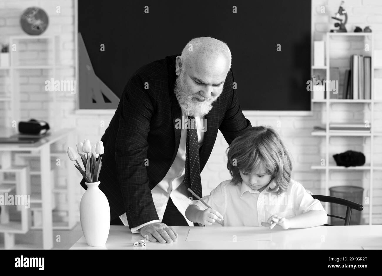 L'enseignant de l'école aide à apprendre. Un élève qui apprend en classe. Éducation, enseignement. Leçon enfant élève. Banque D'Images