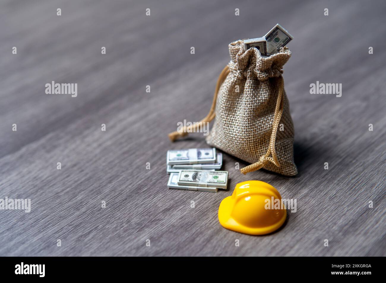 Gros plan image un sac d'argent et un casque sur une table en bois. Concept d'indemnisation des accidents du travail. Banque D'Images