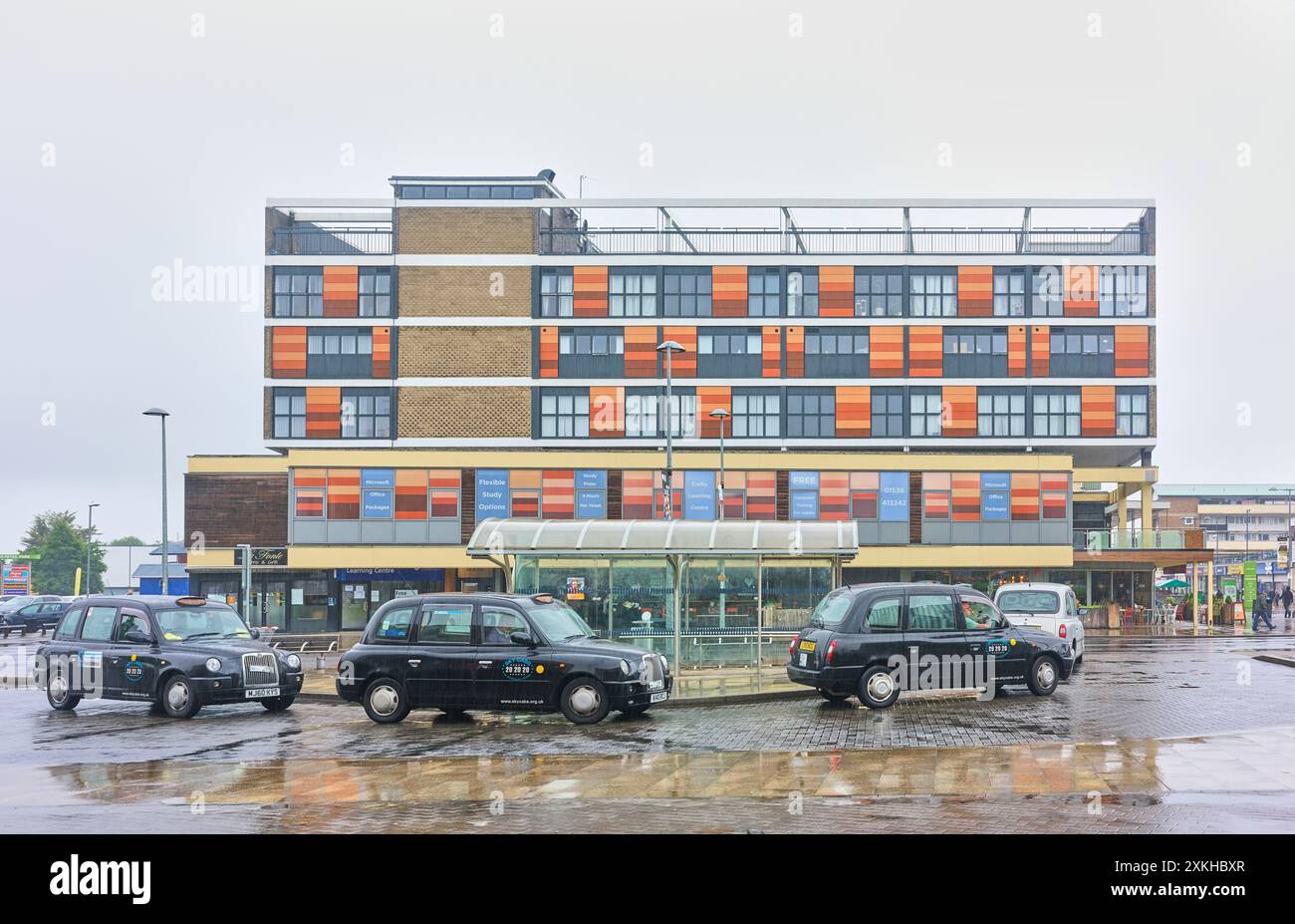 La station de taxis un jour de pluie dans le centre commercial du centre-ville de Corby et Willow place. Banque D'Images