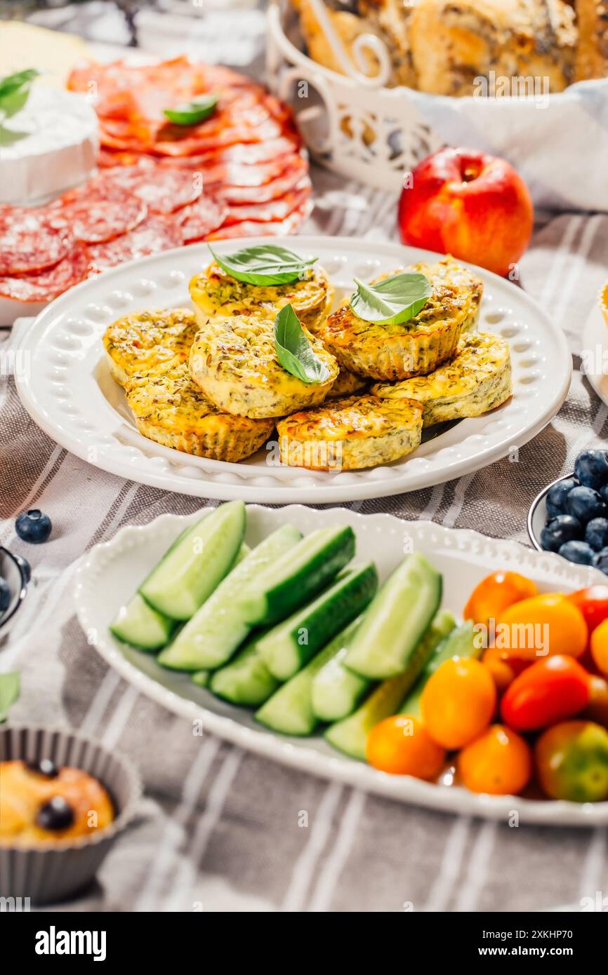 Pique-nique, hors-d'œuvre et plateau de fromage et de viande avec muffins sucrés et salés et fruits Banque D'Images