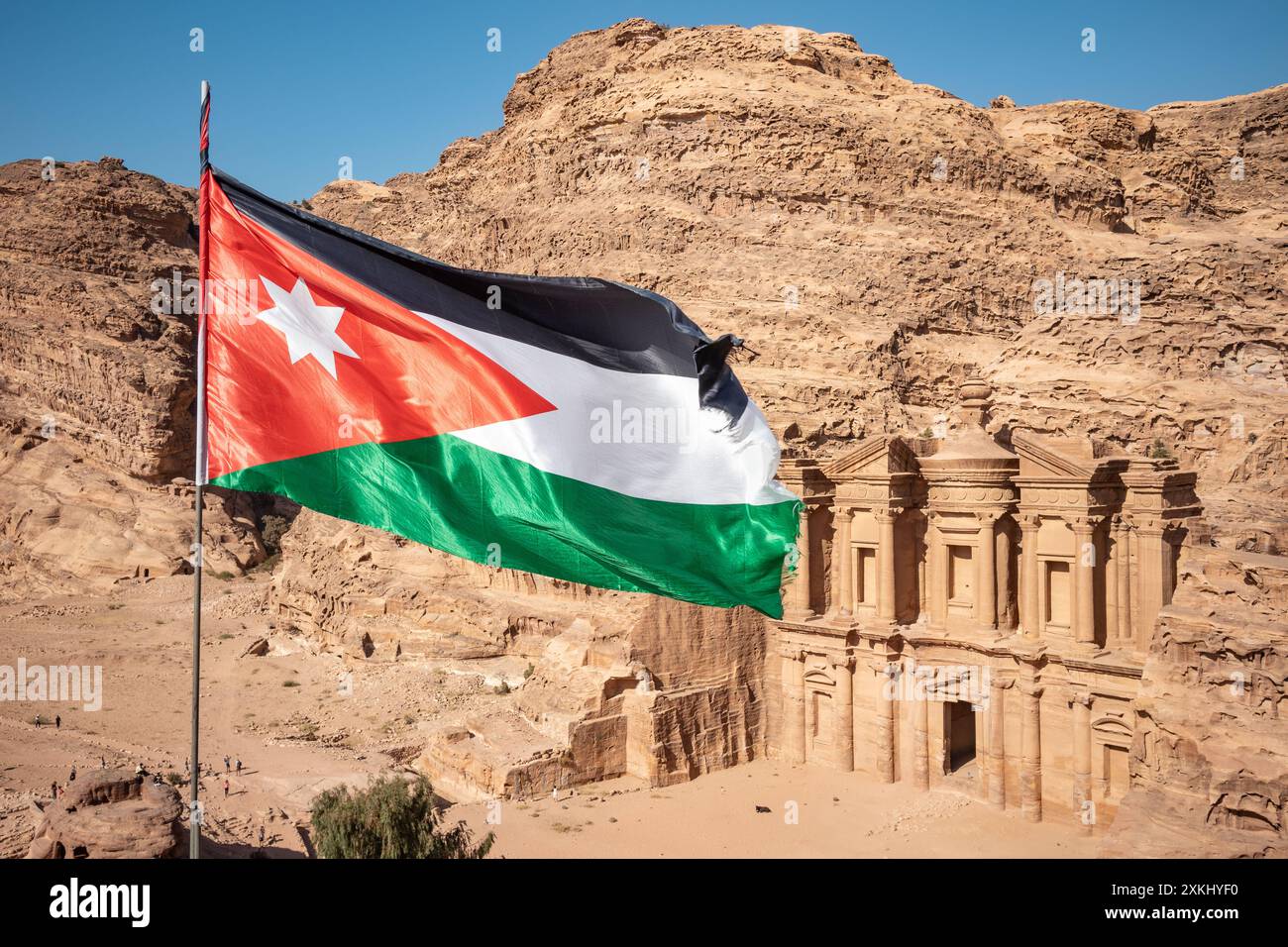 Ed-Deir est un bâtiment monumental taillé dans la roche dans la ville archéologique de Pétra en Jordanie. Drapeau jordanien au moyen-Orient. Banque D'Images