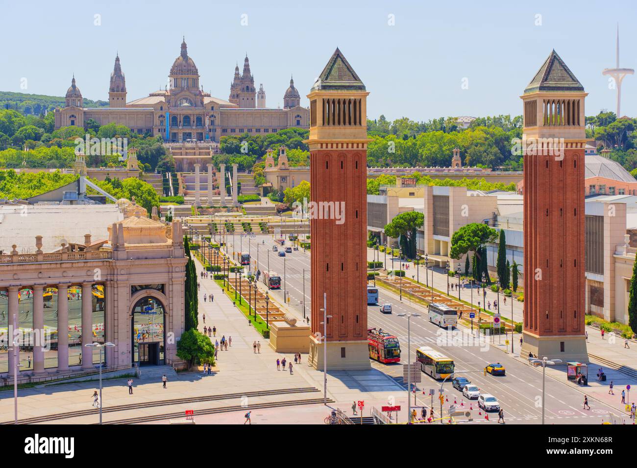 Barcelone, Espagne - 16 juillet 2024 : vue imprenable sur les tours jumelles emblématiques en face du Palau Nacional avec une végétation luxuriante et la vie urbaine animée environnante Banque D'Images