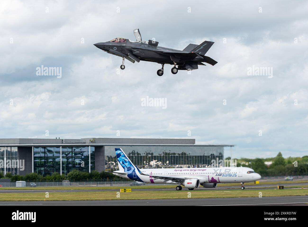 Le chasseur à réaction RAF Lockheed Martin F-35B Lightning II survolant un Airbus A321XLR - Extra long Range - au salon international de l'aéronautique de Farnborough 2024, Royaume-Uni Banque D'Images