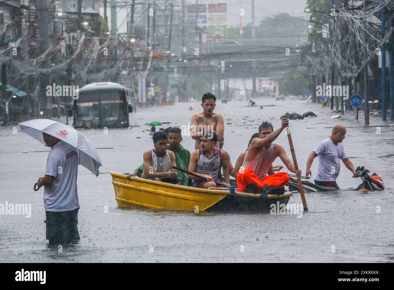 Quezon City, Philippines. 24 juillet 2024. Des résidents rament un bateau dans une rue inondée à Quezon City, aux Philippines, le 24 juillet 2024. Les Philippines ont été secouées par les pluies incessantes de la mousson renforcée du sud-ouest apportée par le typhon Gaemi, qui a amené le conseil du Grand Manille à déclarer mercredi un état de calamité dans la région de la capitale nationale. Crédit : Rouelle Umali/Xinhua/Alamy Live News Banque D'Images