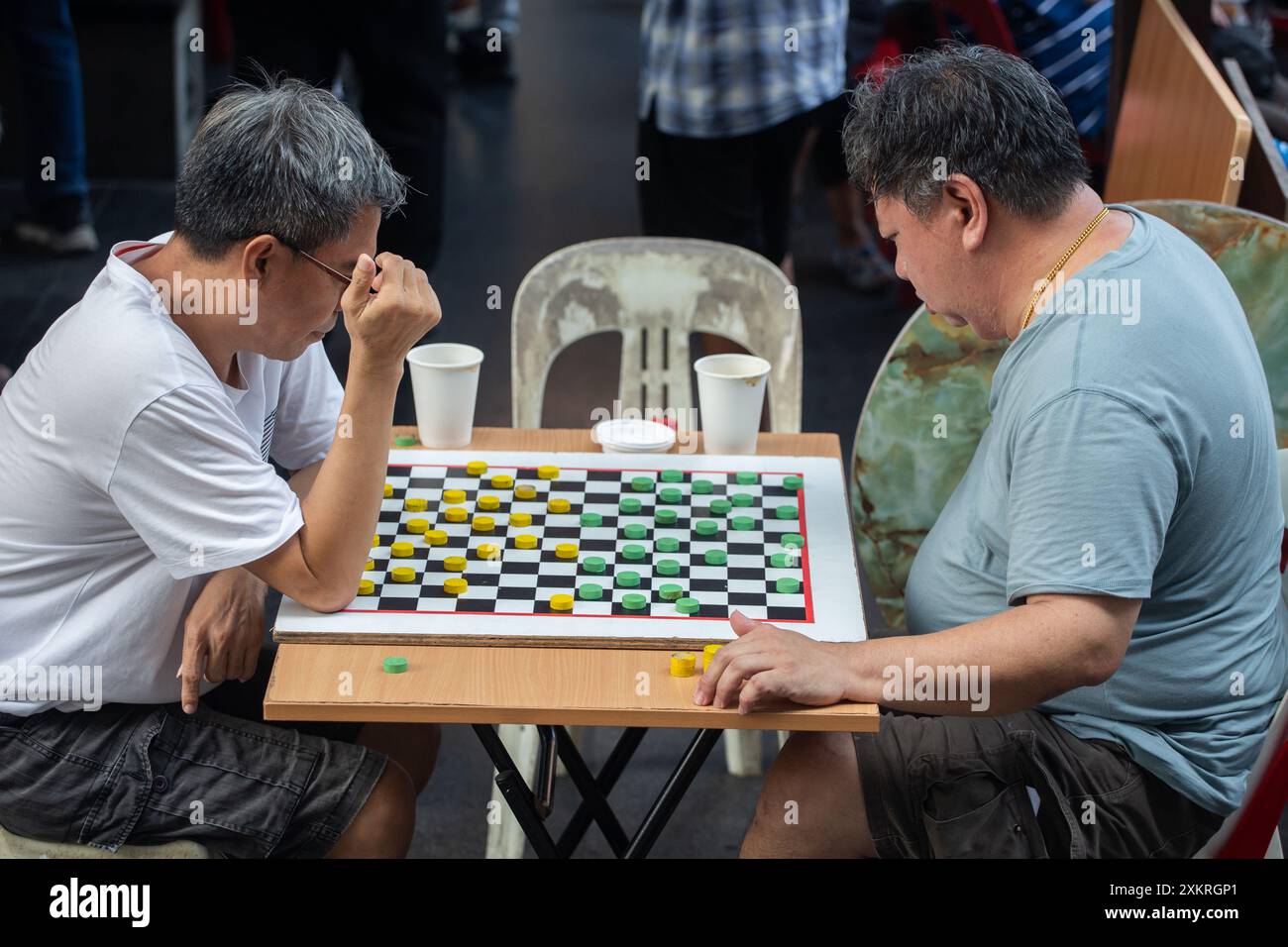 Deux hommes chinois d'âge moyen jouent un jeu d'échecs compétitif l'un contre l'autre à Chinatown, Singapour. Banque D'Images Deux hommes chinois d'âge moyen jouent un jeu d'échecs compétitif l'un contre l'autre à Chinatown, Singapour. Banque D'Images