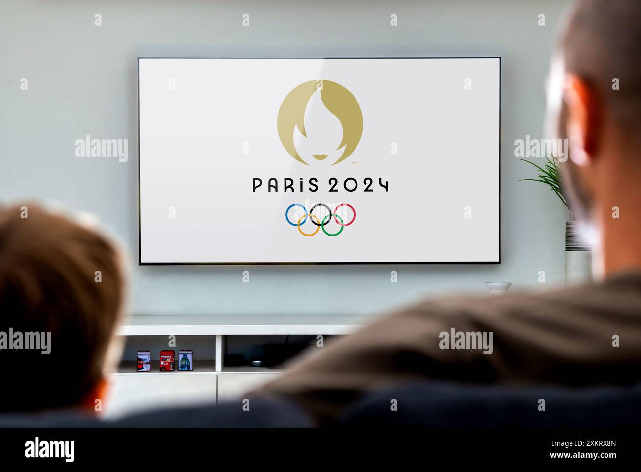 Homme et son fils regardant les Jeux Olympiques de Paris 2024 sur Smart TV. Diffusion de courses