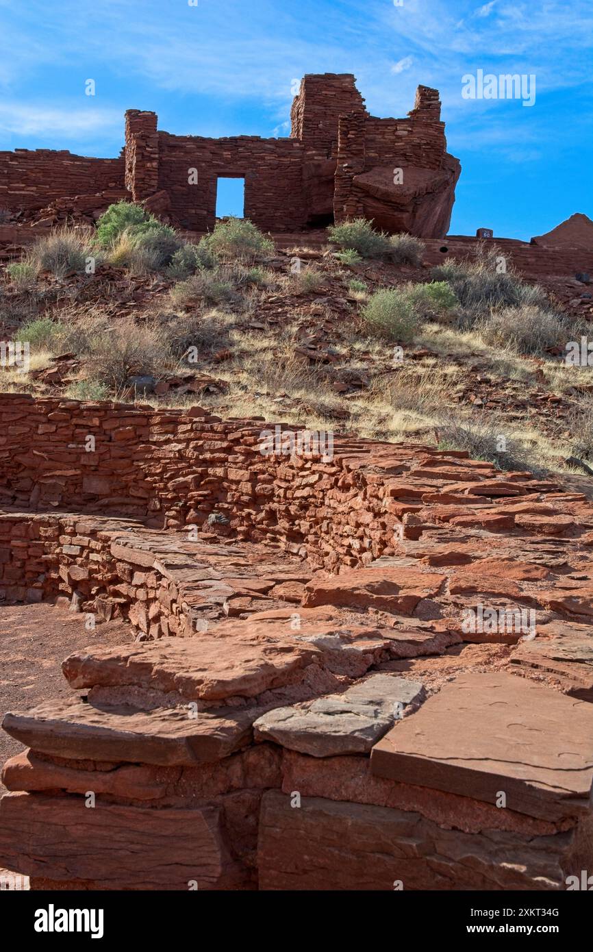 Ruines de pueblo en bloc de grès derrière le terrain de bal récréatif clos de maçonnerie circulaire du village de pueblo de Wupatki Banque D'Images