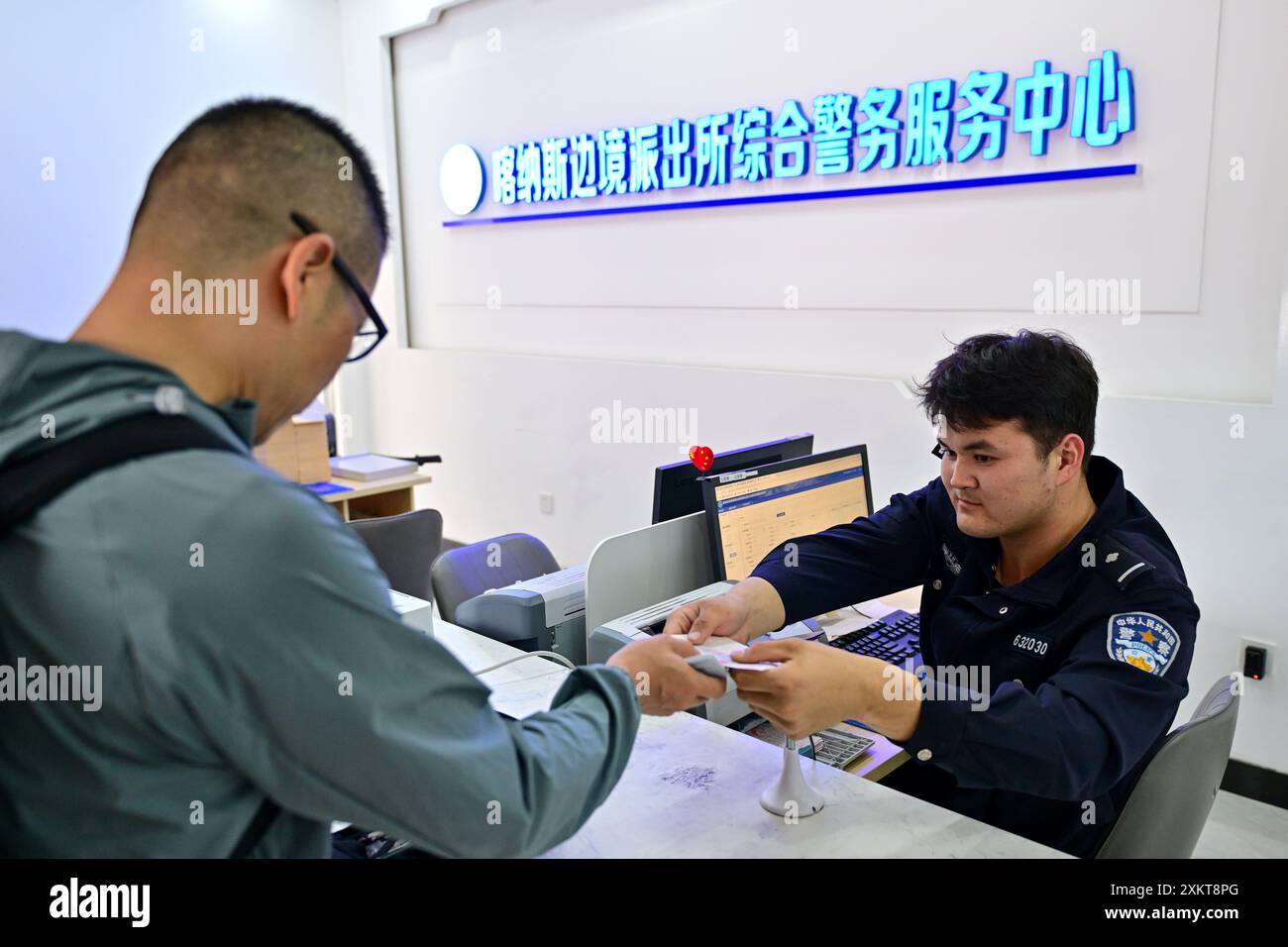 (240724) -- BURQIN, 24 juillet 2024 (Xinhua) -- Un policier manipule le laissez-passer frontalier d'un touriste à un poste de service du poste de police frontalier de Kanas dans la zone pittoresque de Kanas à Altaï, dans la région autonome ouïgur du Xinjiang, au nord-ouest de la Chine, 22 juillet 2024. Le poste de police frontalière de Kanas est situé dans le quartier pittoresque de Kanas à Altay. Ces dernières années, l'industrie du tourisme à Altay s'est développée vigoureusement. Selon les policiers de la station, la zone pittoresque de Kanas reçoit un maximum de 20 000 touristes par jour. La station a Uni ses forces avec la population locale et le personnel de Scenic Banque D'Images