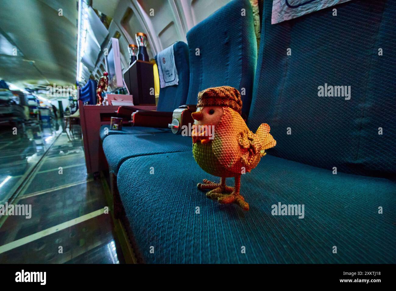 Poulet tricoté fantaisiste sur le siège de l'avion dans la cabine originale Banque D'Images