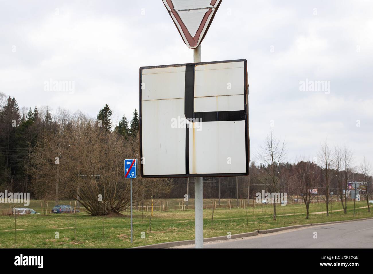 Un panneau portant la lettre f est visible. Il se distingue parmi les éléments naturels tels que les plantes, les nuages, les arbres et la route Banque D'Images