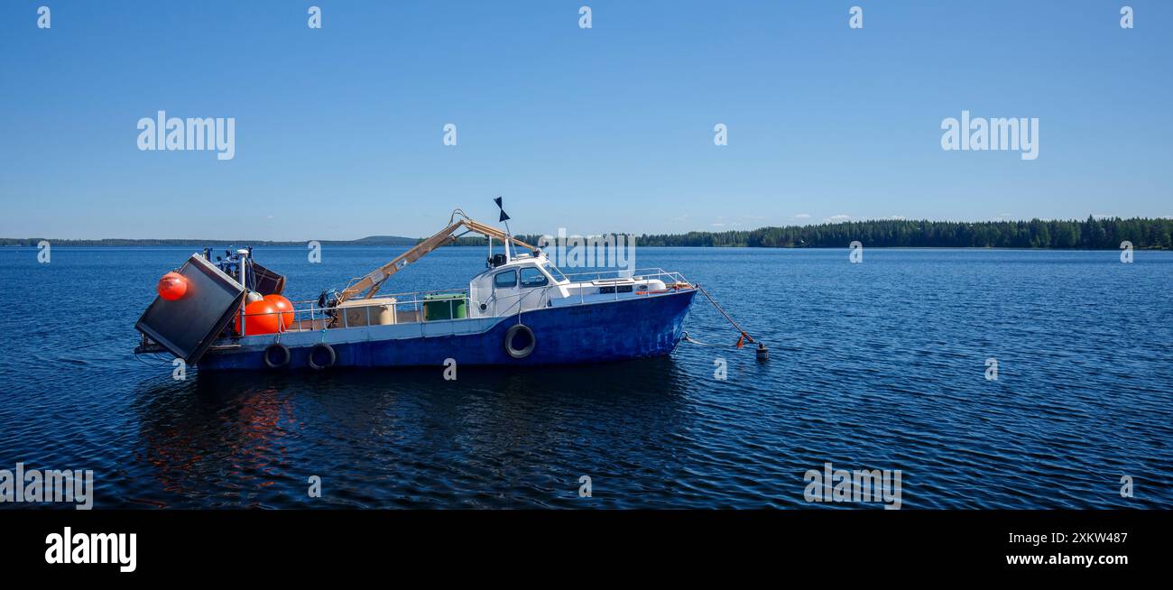 Petit chalutier finlandais de pêche lacustre ancré derrière le brise-lames du lac Pohjois-Konnevesi , Finlande Banque D'Images