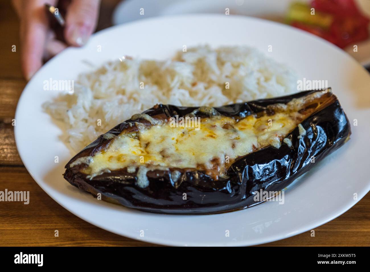 Aubergines grillées farcies au fromage servies avec du riz sur une assiette blanche. Plat traditionnel arménien. Goris, Arménie. Banque D'Images