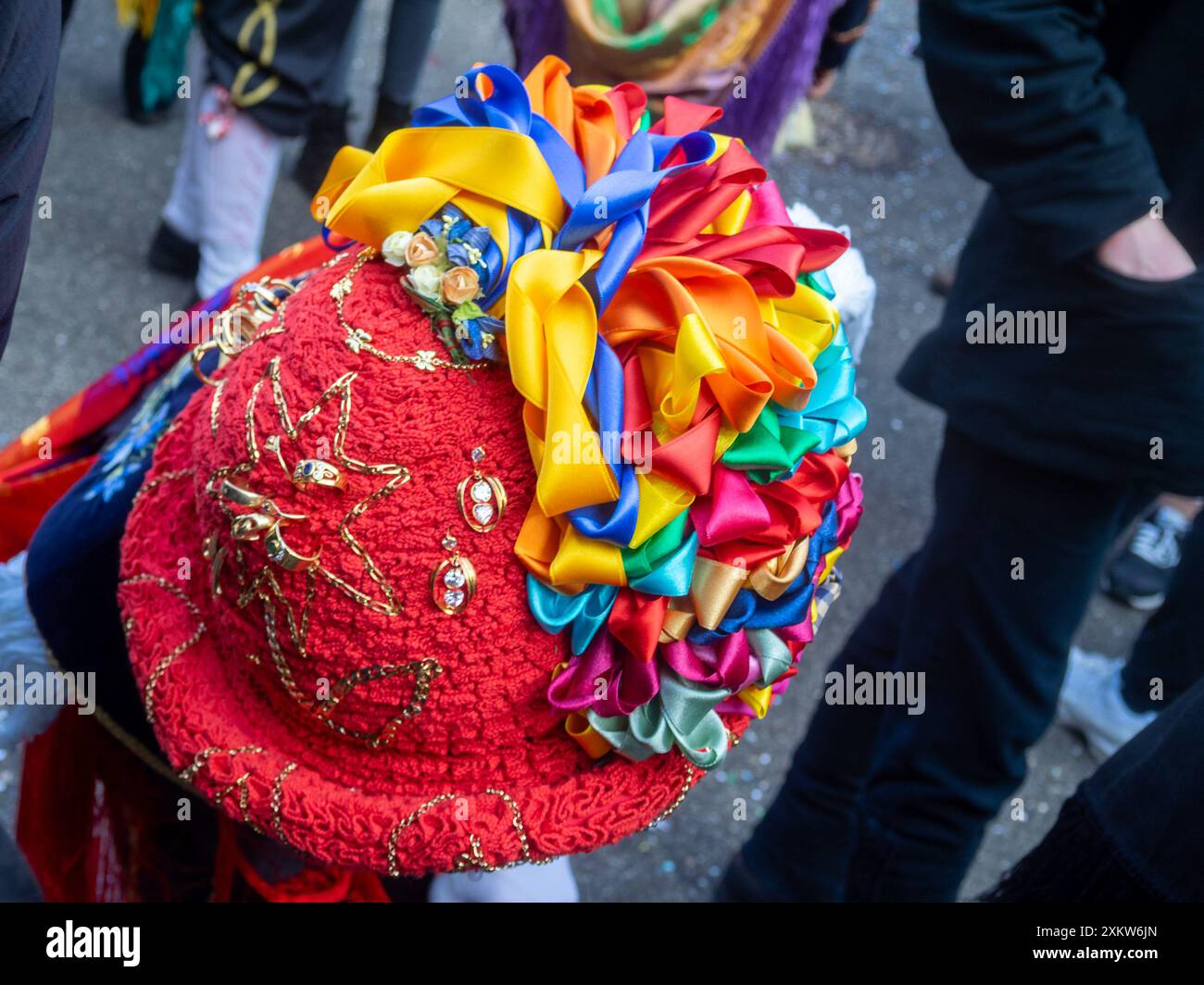 Vue de dessus d'un chapeau en feutre Balarì, recouvert d'un ruban rouge plié, orné de broderies, de bijoux en or, de la famille ou empruntés, et de rubans multicolores en forme d'arc, carnaval Bagolino Banque D'Images
