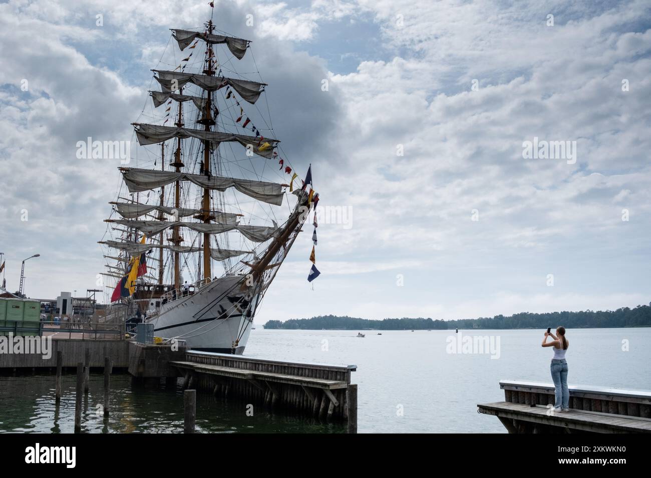 MARIEHAMN, Åland, FINLANDE - 24 JUILLET 2024 : les gens admirent et photographient le gigantesque voilier Guayas depuis l'Équateur. Premier jour des trois jours Åland Stage de la course de grands voiliers 2024 dans le port principal, Mariehamn, Åland, Finlande. Photo : Rob Watkins/Alamy Live News. INFO : la Tall Ships Race est un événement annuel de voile mettant en vedette des grands voiliers historiques et modernes. Il promeut l'amitié internationale et la formation des jeunes, attirant des participants et des spectateurs du monde entier pour célébrer le patrimoine maritime et l'art de la voile traditionnelle. Banque D'Images