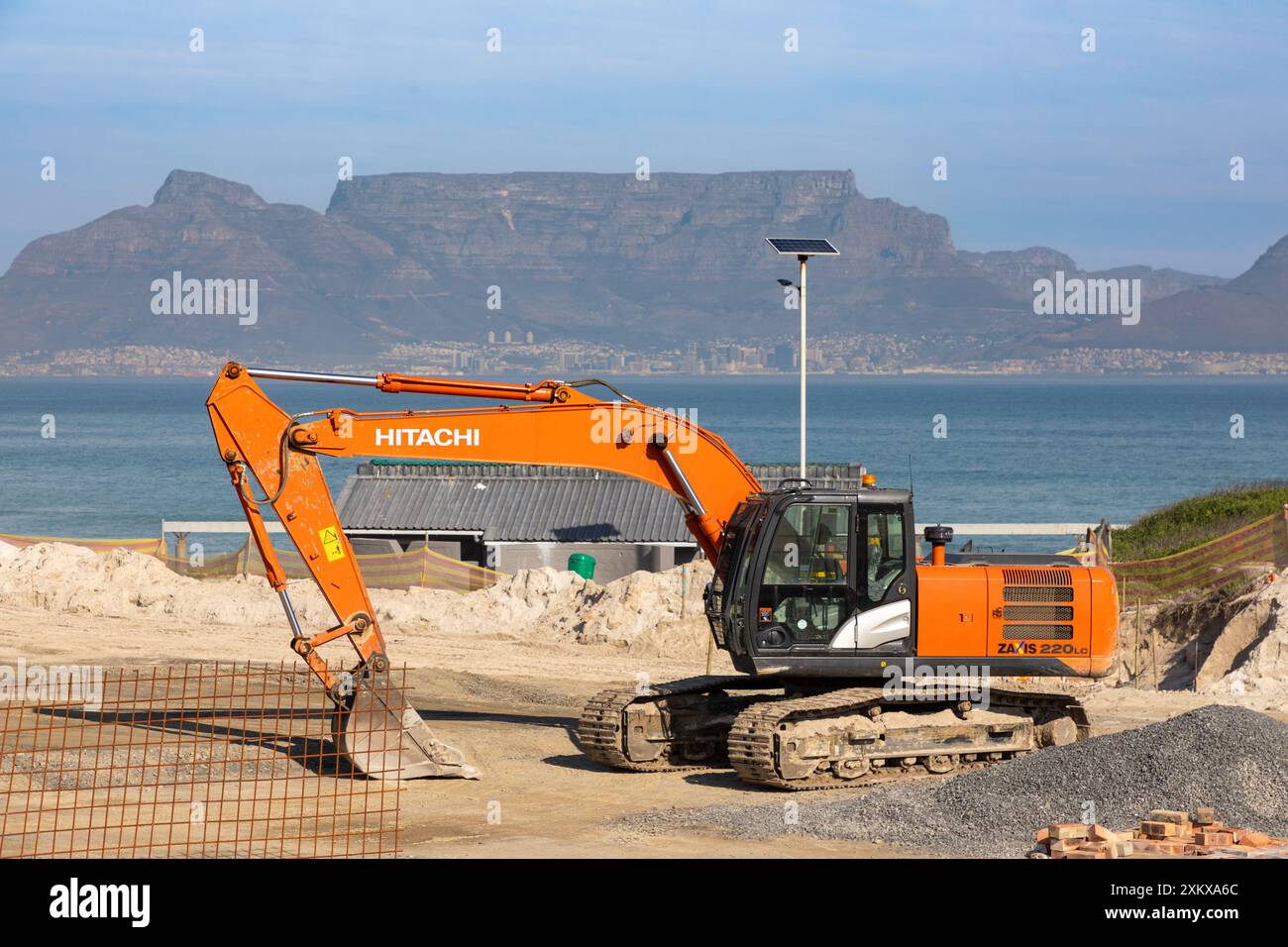 Gros plan sur une pelle HITACHI sur un chantier de construction à Bloubergstrand, au Cap. Table Mountain en arrière-plan. Banque D'Images
