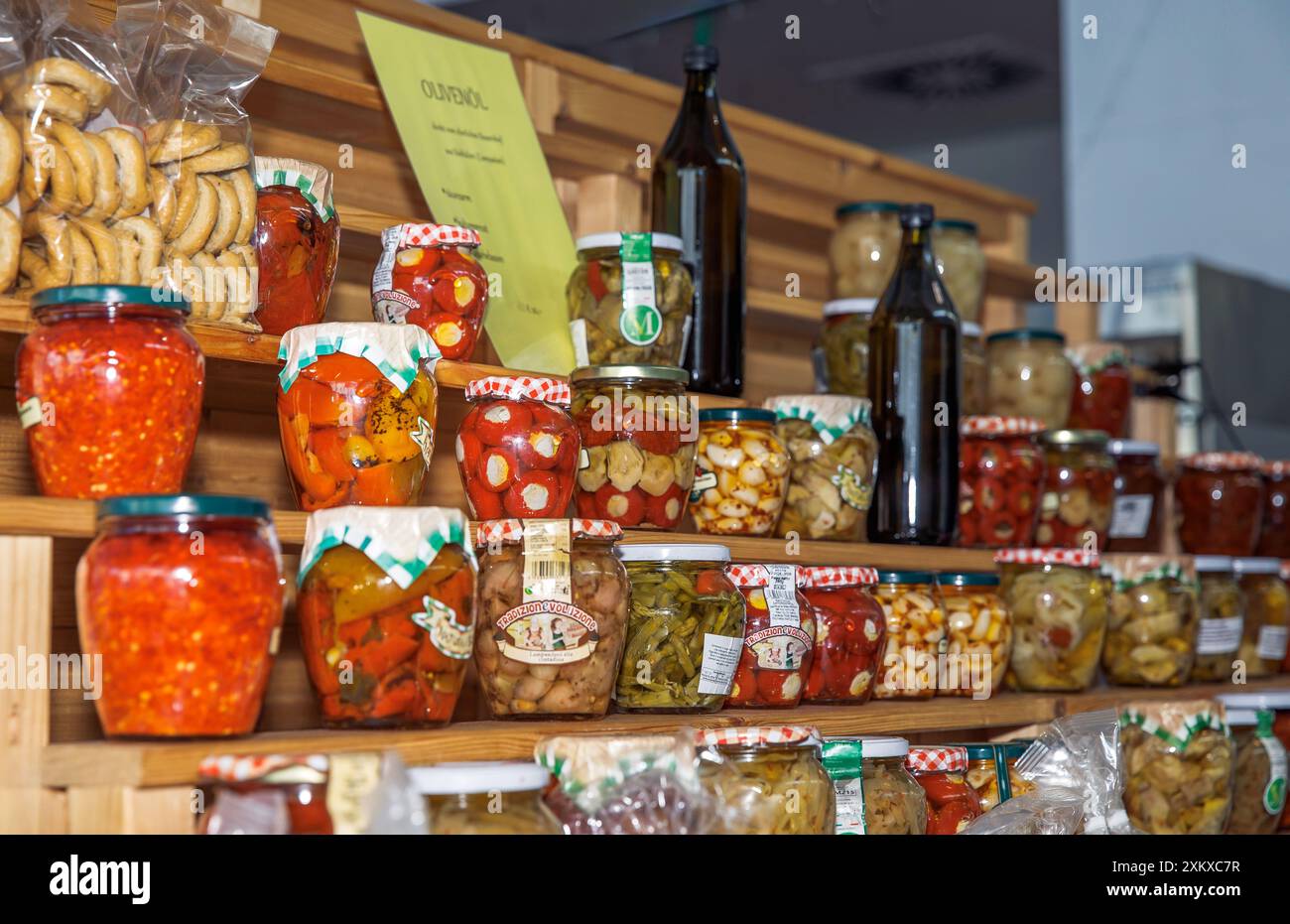 Étagères en bois remplies de légumes et de fruits conservés dans divers pots exposés sur un marché local, concept de conservation des aliments Banque D'Images
