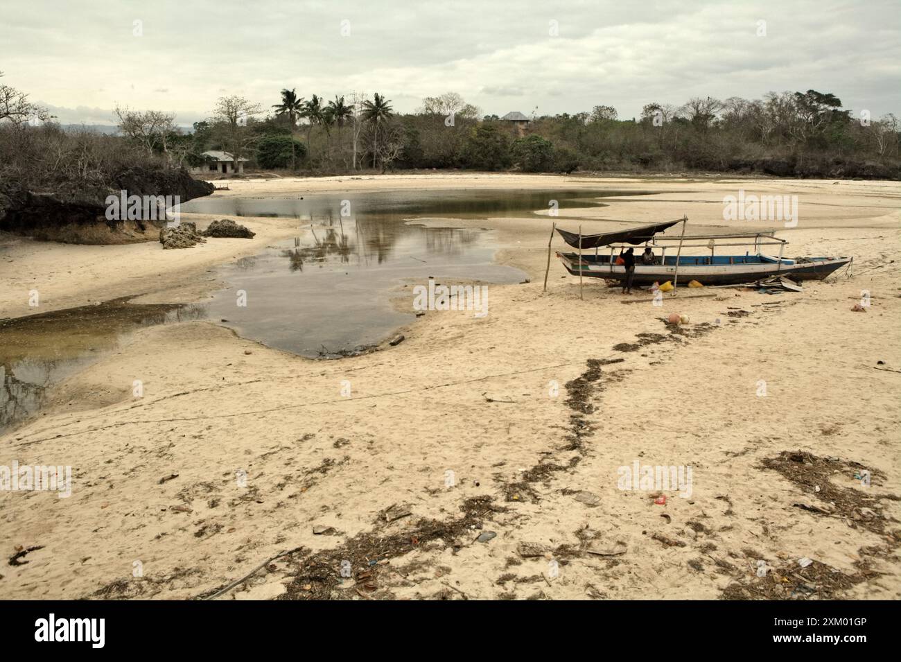 Un bateau de pêche sur la plage intertidale à marée basse à Waikelo, Tambolaka, Sumba sud-ouest, Nusa Tenggara est, Indonésie. Banque D'Images
