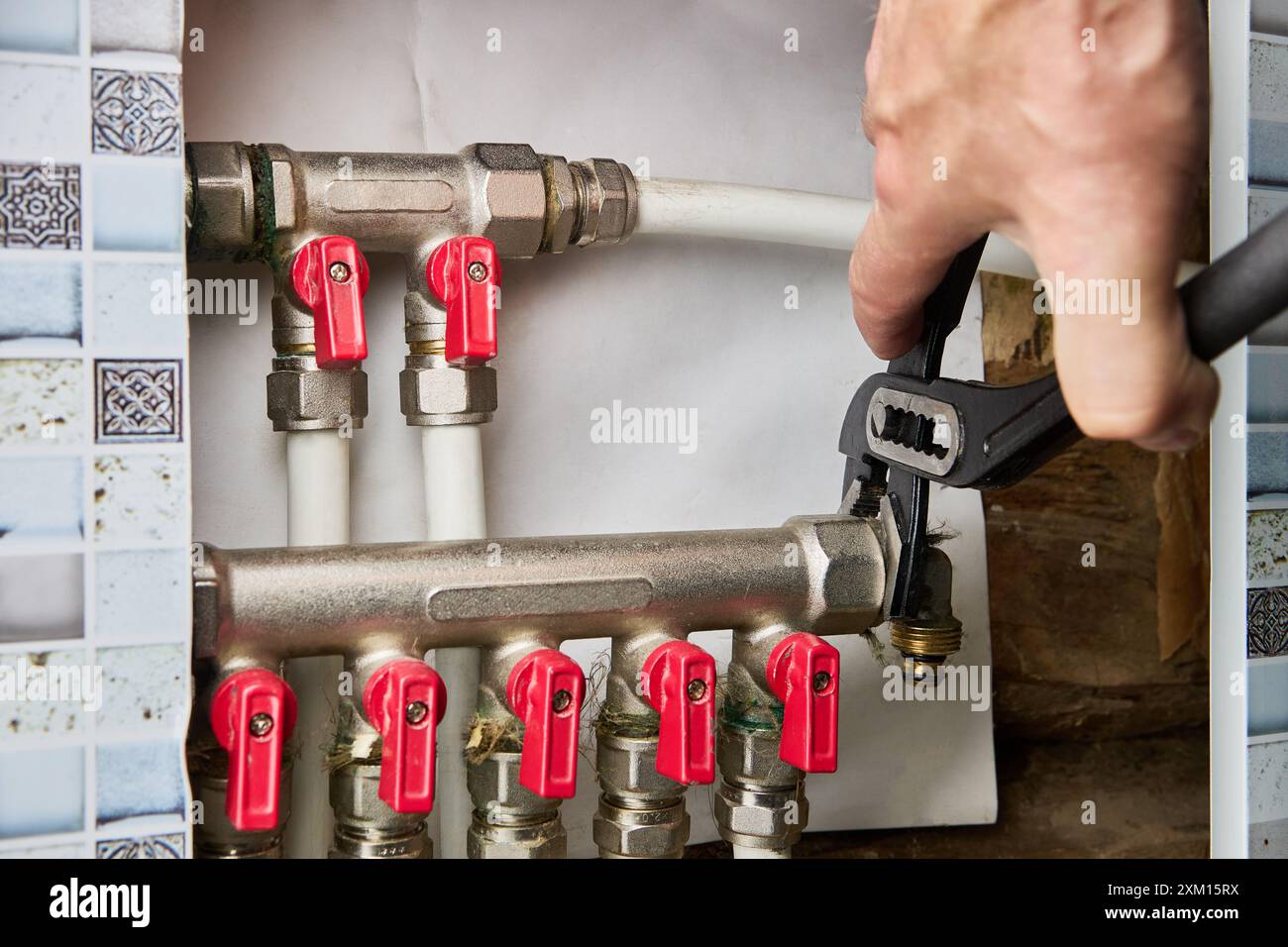 L'adaptateur de raccord coudé avec filetage externe et raccord de compression est dévissé avec une clé à plombier pour la réparation. Banque D'Images