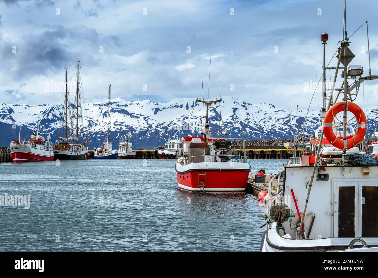 Bateaux de pêche colorés rouges et blancs dans le port de la petite ville de Husavik dans le nord de l'Islande Banque D'Images