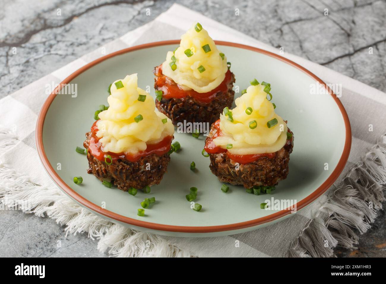 Buffet muffins à la viande garni de ketchup et de purée de pommes de terre gros plan dans une assiette sur la table. Horizontal Banque D'Images