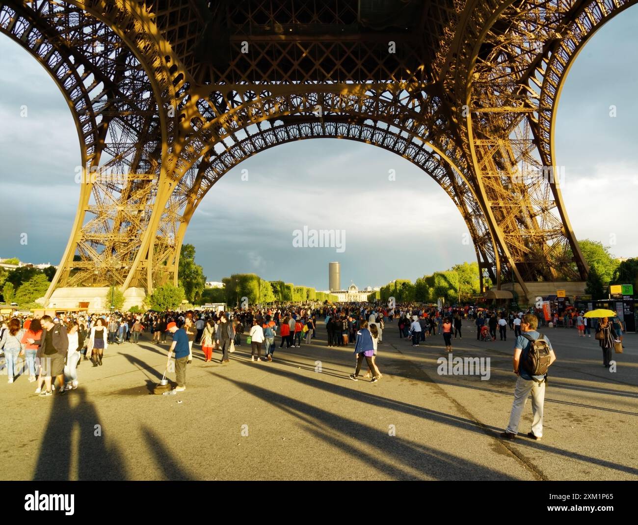 Touristes marchant sous la Tour Eiffel. Paris. Banque D'Images