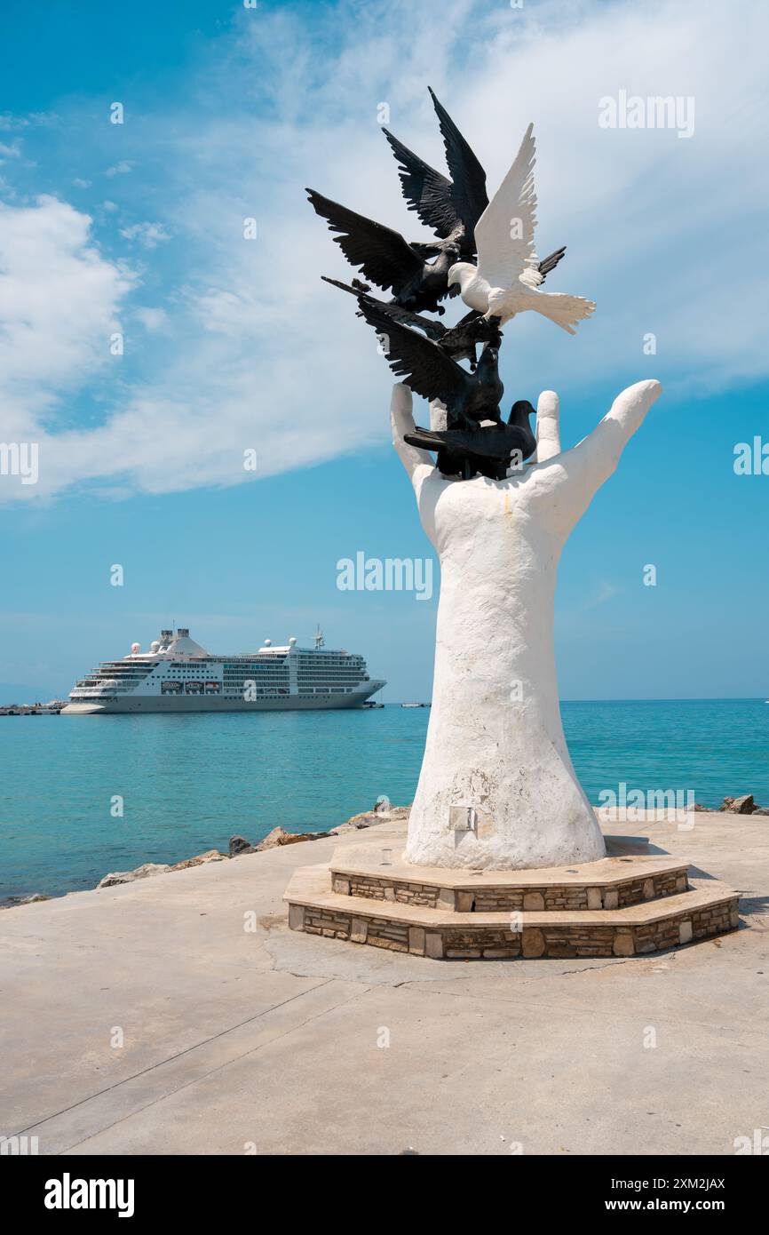 Aydin Kusadasi, Turquie - 4 juillet 2024 : sculpture de la main de la paix et bateau de croisière derrière elle à Kusadasi Aydin Banque D'Images
