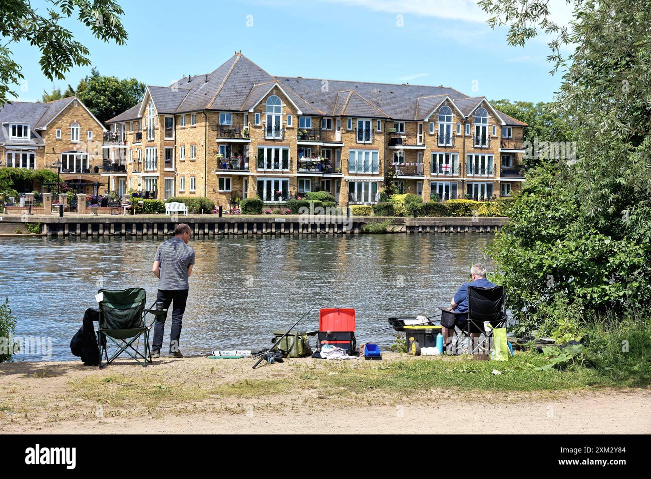 Deux hommes d'âge moyen pêchant dans la Tamise à Walton un jour d'été ensoleillé Surrey Angleterre Royaume-Uni Banque D'Images