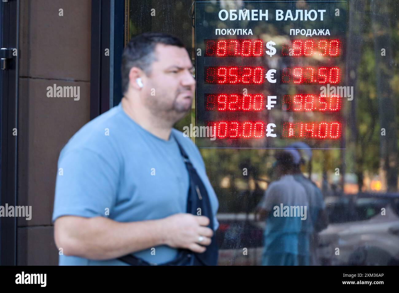 Homme près du bureau de change sur la rue de la ville, taux du rouble russe, dollar américain, euro Banque D'Images