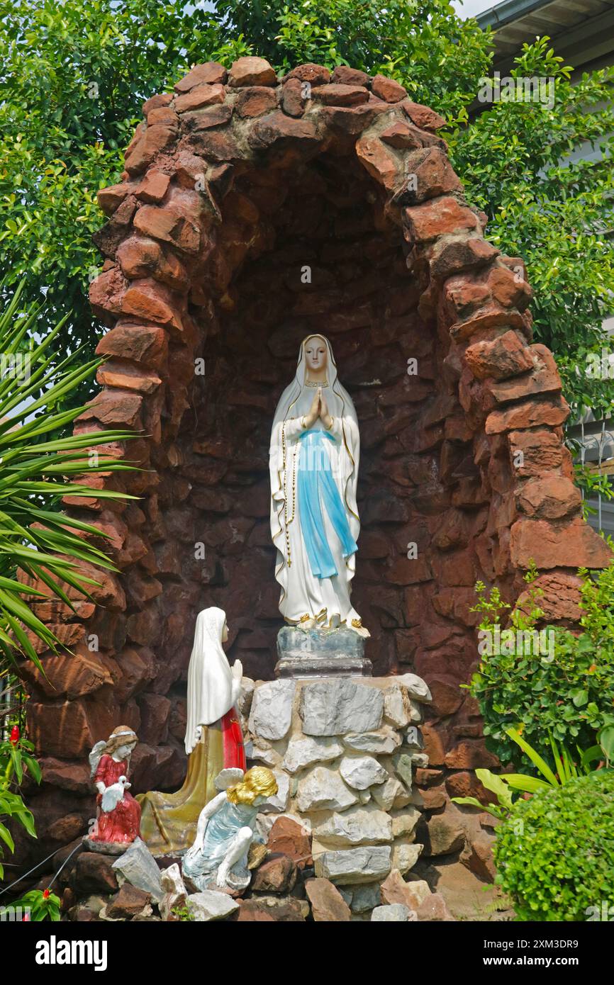 Sculpture de notre-Dame de Lourdes dans le jardin de l'église catholique Santa Cruz sur Chao Phraya Riverbank, quartier de Kudi Chin à Bangkok, Thaïlande Banque D'Images