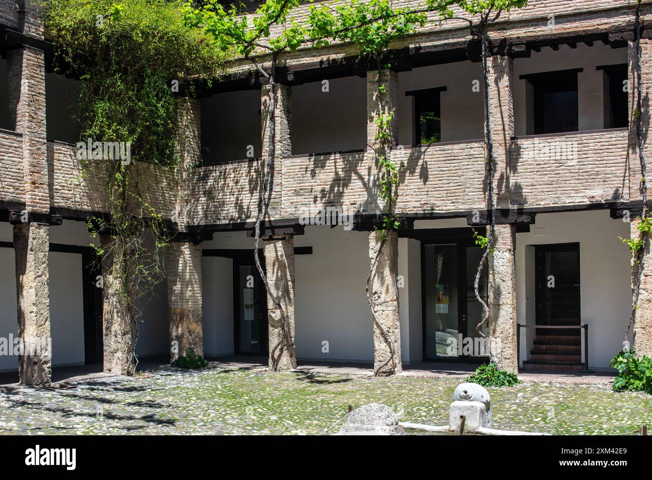 Une scène de cour paisible de Corral del Carbon, un bâtiment public historique à Grenade, Andalousie, Espagne. Architecture rustique et verdure. Banque D'Images