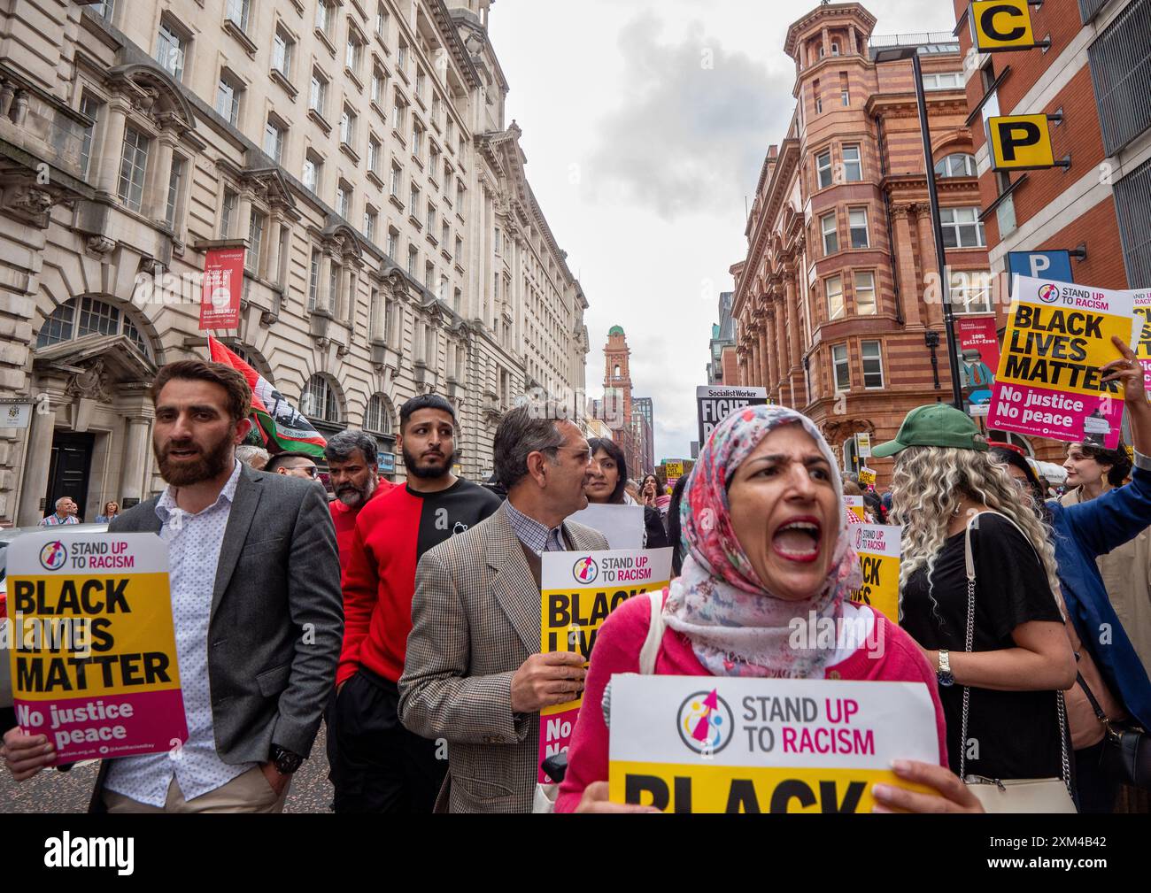 Nahella Ashraf de 'Stand Up to Racism' (foulard) mène des protestations. Greater Manchester Stand Up To Racism (GMSUTR) a organisé une manifestation aujourd'hui dans les bureaux du maire de Manchester Combined Authority (GMCA) Andy Burnham sur Oxford Street, dans la ville de Manchester. Les manifestants ont exigé la fin immédiate des violences policières racistes de la police du Grand Manchester (GMP) suite à une vidéo récemment diffusée, capturée mardi soir au terminal 2 de l’aéroport de Manchester. La vidéo montre un officier frappant un membre du public au visage suivi par l'officier tamponnant sur le HE de l'individu Banque D'Images