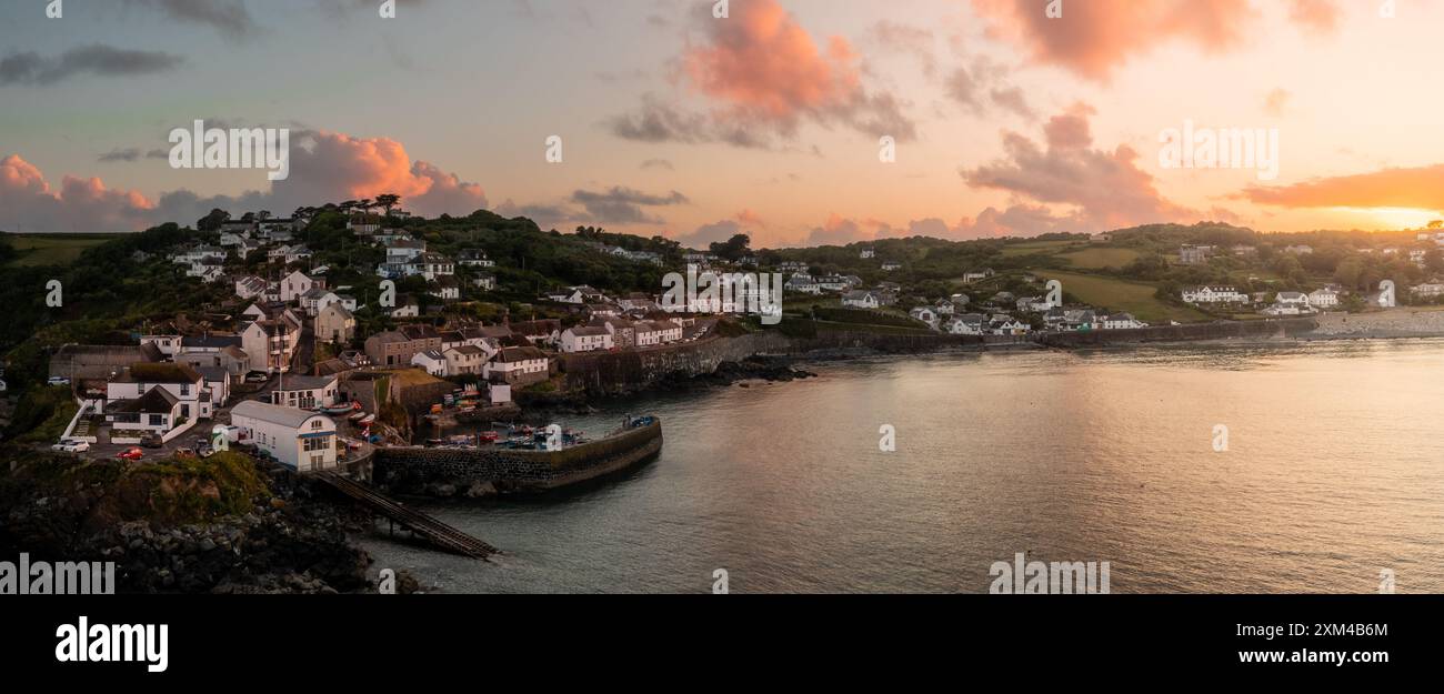 Paysage aérien du pittoresque village de pêcheurs de Cornouailles de Coverack en Cornouailles avec une côte rocheuse et un port historique avec un ciel spectaculaire au coucher du soleil Banque D'Images