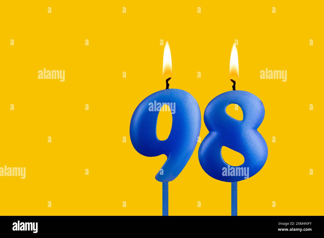 Bougie bleue numéro 98 - anniversaire sur fond jaune Banque D'Images