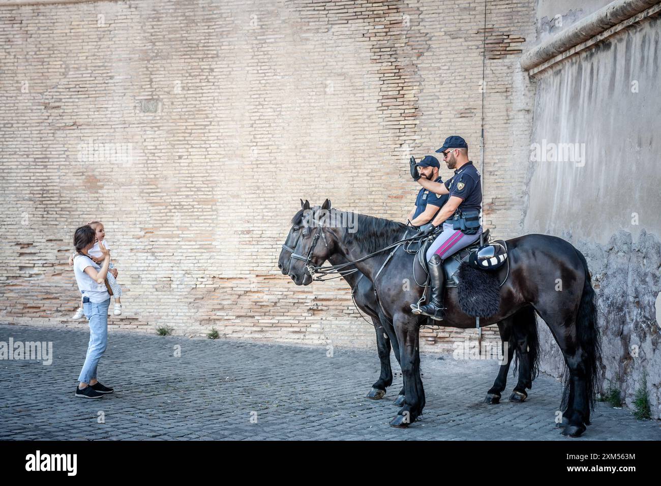 Photo d'une jeune fille saluant Polizia a cavallo, la police montée italienne (à cheval) à rome, italie. « Polizia a cavallo » fait référence au po monté Banque D'Images